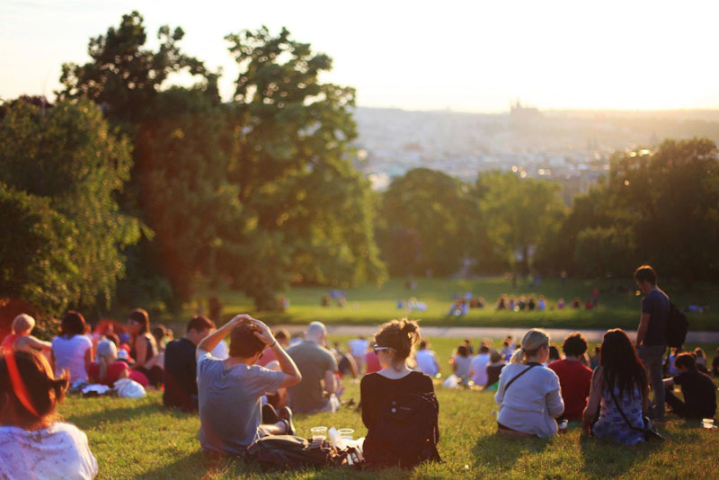 summer day outside people sit on hilltop