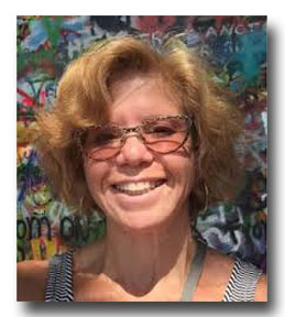 Marilyn Stein is a smiling woman with glasses and wavy light-brown hair