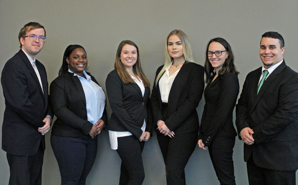 Six college students in business attire pose.