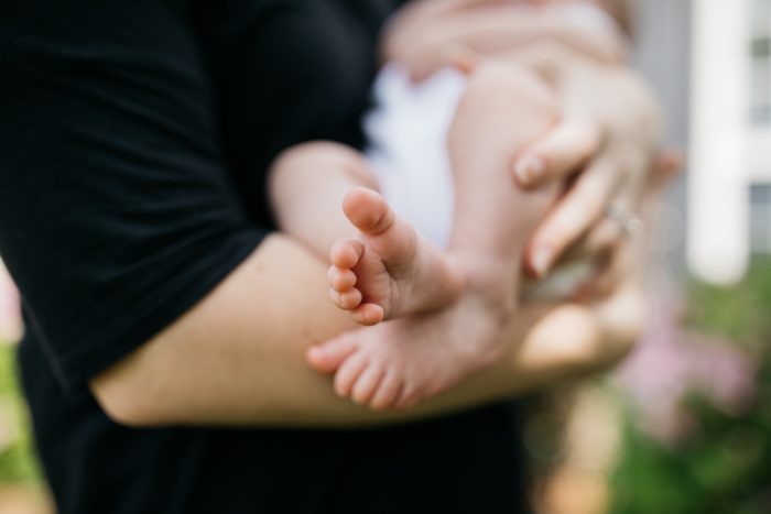 Close up of person in black holding an infant