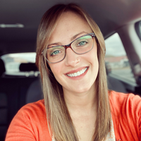 A woman takes a selfie inside a car- she looks professional.