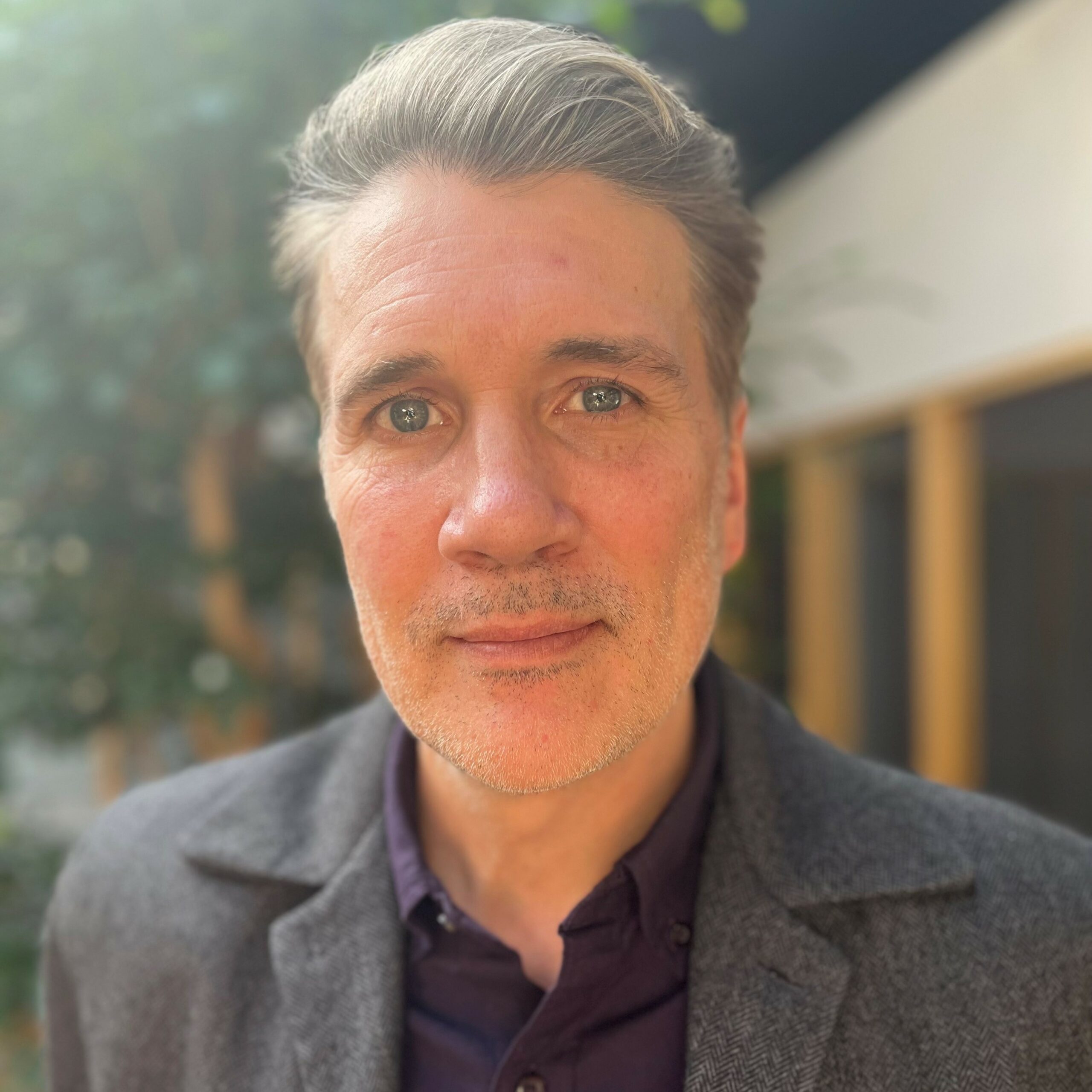 Headshot of a man in business attire- he has kind eyes.