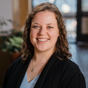 Headshot of a woman in business attire in a light-filled atrium