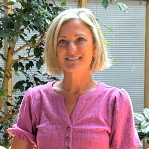 Headshot of a woman in an indoor atrium with fig trees