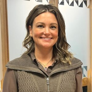 Headshot of a woman in an indoor atrium, smiling.