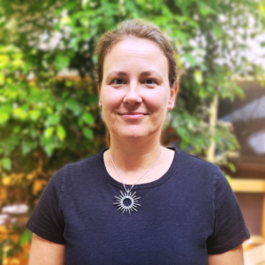 Headshot of a woman in an indoor atrium with plants