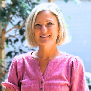 Headshot of a woman in an indoor atrium with fig trees